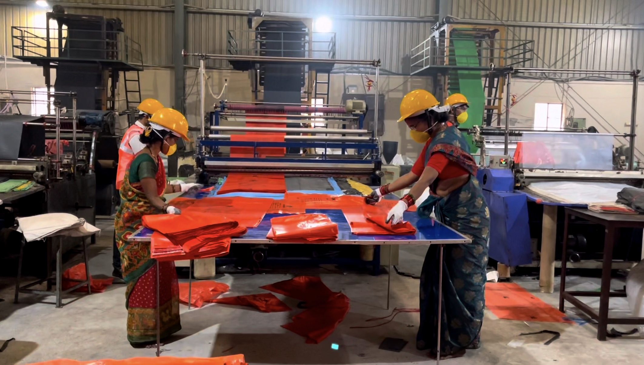 Workers folding bags at Ushakiran Ecoplast manufacturing facility